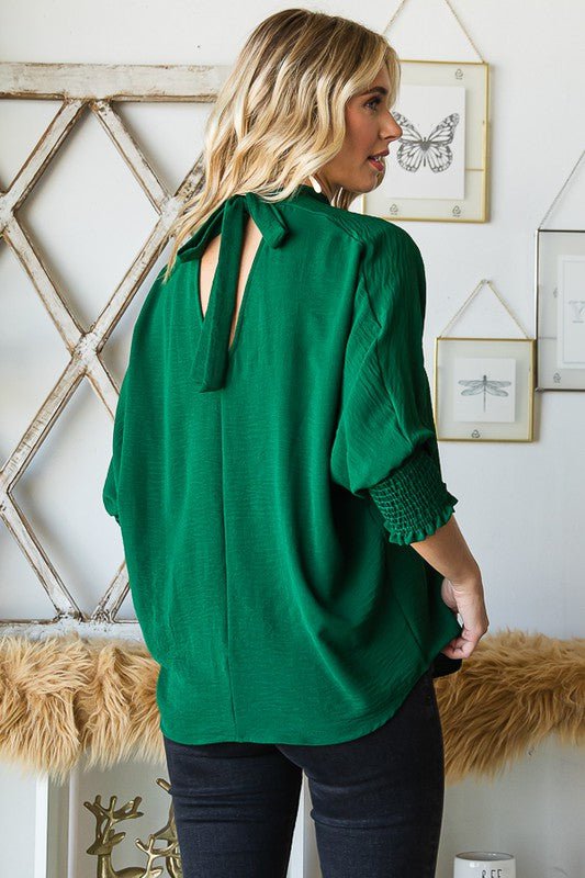 green holiday top with bow accents